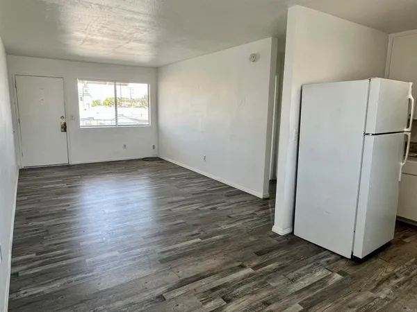a view of a kitchen with wooden floor and a window
