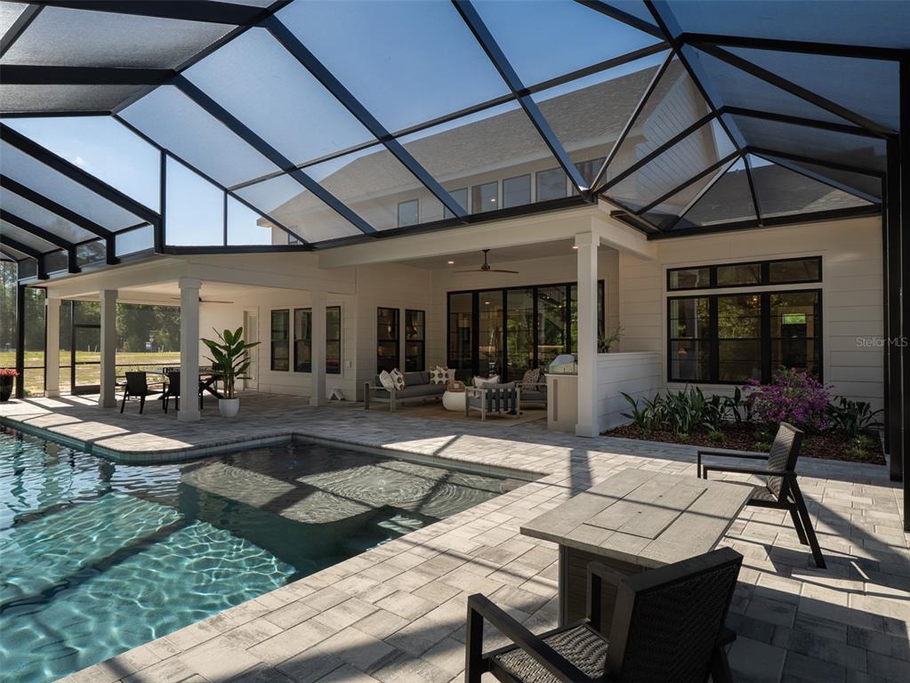 14828 Southwest 9th Lane Newberry, FL 32669 - Photo 35 of 45 a view of a patio with table and chairs potted plants and floor to ceiling window
