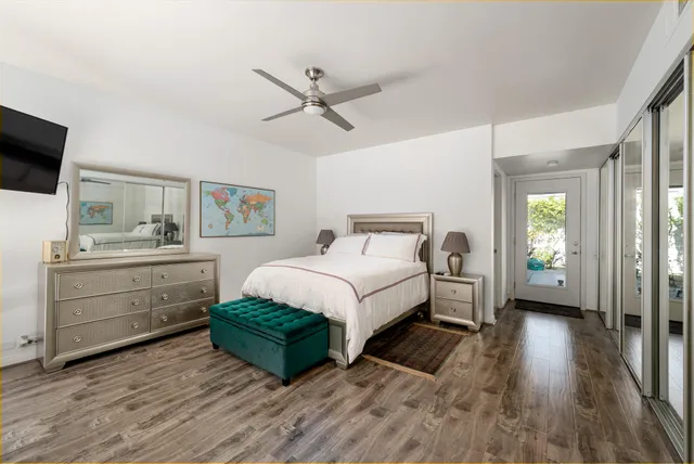 a living room with a balcony furniture flat screen tv and a large window