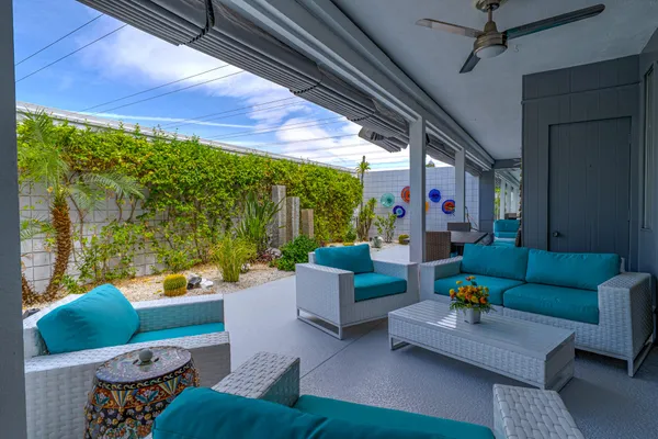 a view of a patio with chairs and potted plants