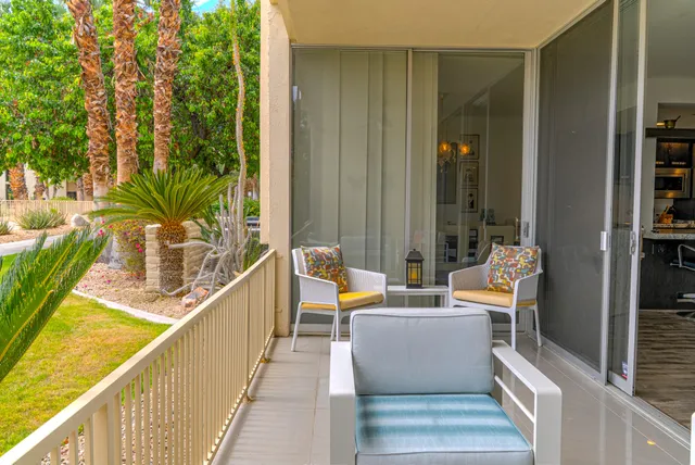 a view of a swimming pool with a lawn chairs under palm trees