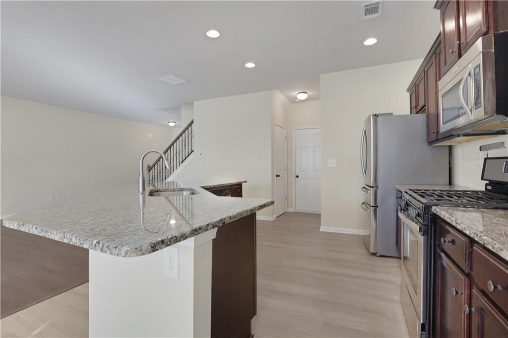2526 Morgan Chase Drive Buford, GA 30519 - Photo 14 of 44 a kitchen with stainless steel appliances granite countertop a sink a stove and a refrigerator