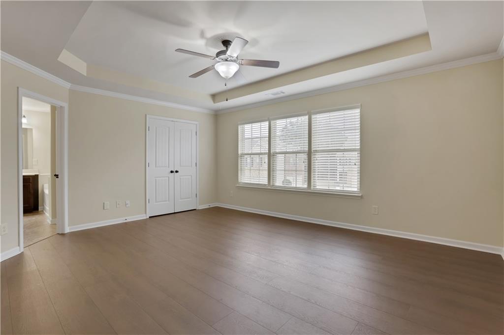 2526 Morgan Chase Drive Buford, GA 30519 - Photo 19 of 44 an empty room with wooden floor chandelier fan and windows
