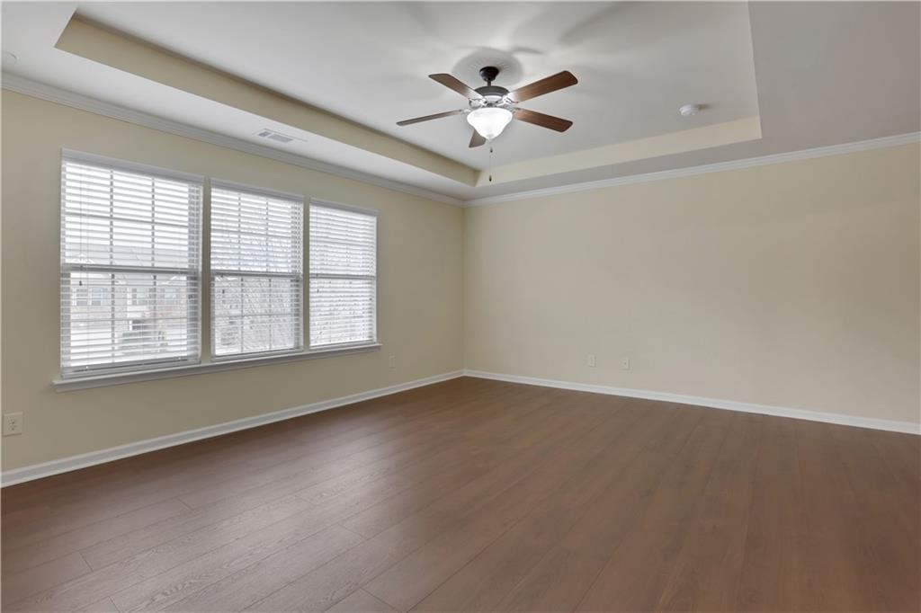 2526 Morgan Chase Drive Buford, GA 30519 - Photo 22 of 44 an empty room with wooden floor ceiling fan and windows