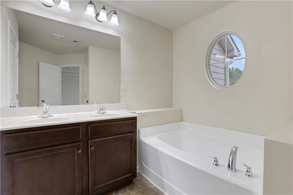 2526 Morgan Chase Drive Buford, GA 30519 - Photo 25 of 44 a bathroom with a bathtub a sink and a mirror