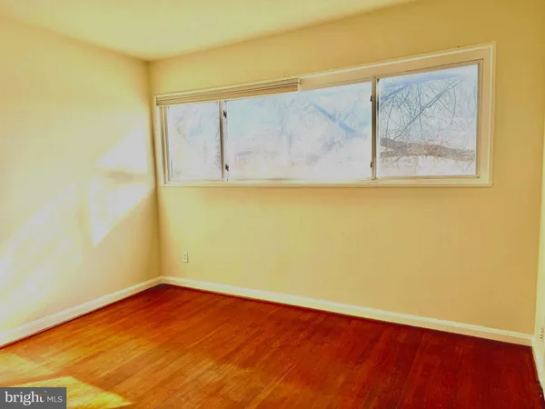 a view of a small space with wooden floor and a window