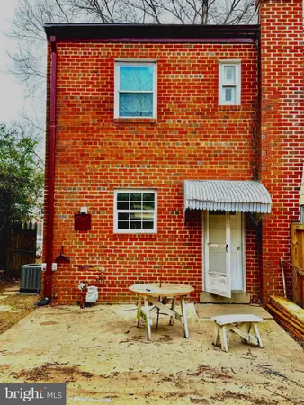 a view of a brick house with lawn chairs
