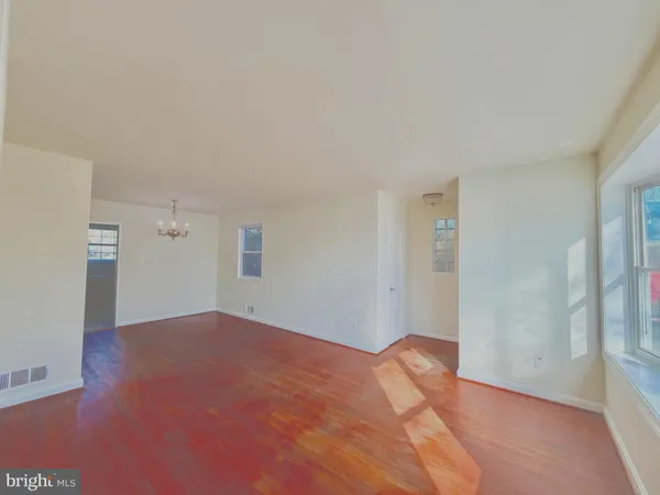 a view of a big room with wooden floor and windows