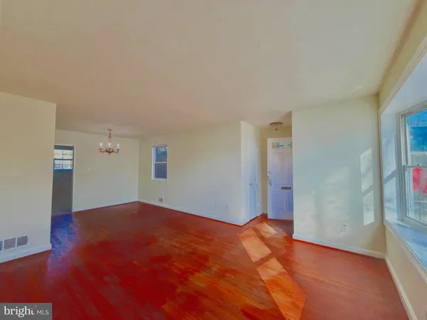 a view of a big room with wooden floor and windows