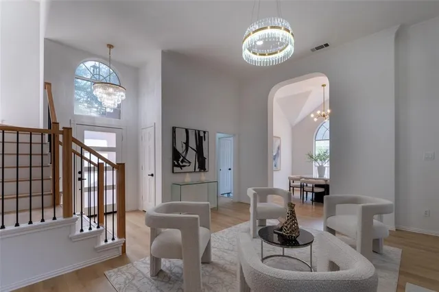 a living room with furniture chandelier and a mirror