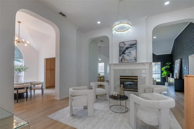 a living room with furniture a fireplace and a potted plant
