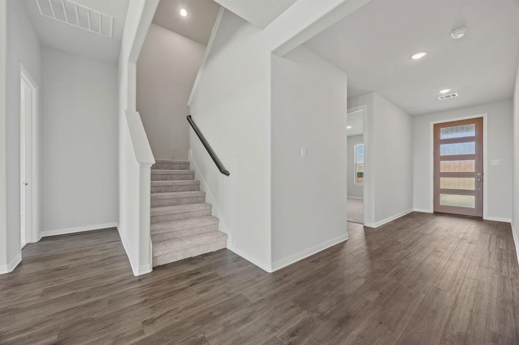 1502 Red Clover Avenue Van Alstyne, TX 75495 - Photo 4 of 27 a view of a hallway with wooden floors and stairs