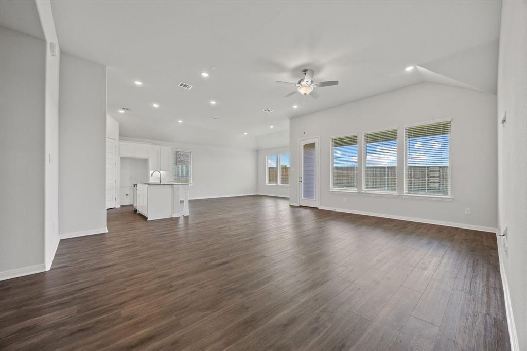 1502 Red Clover Avenue Van Alstyne, TX 75495 - Photo 5 of 27 a view of empty room with wooden floor and kitchen view
