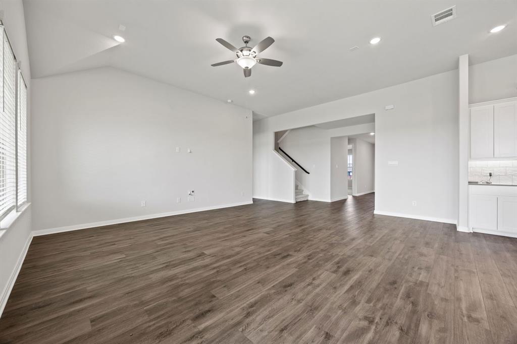 1502 Red Clover Avenue Van Alstyne, TX 75495 - Photo 8 of 27 a view of an empty room with wooden floor and a ceiling fan