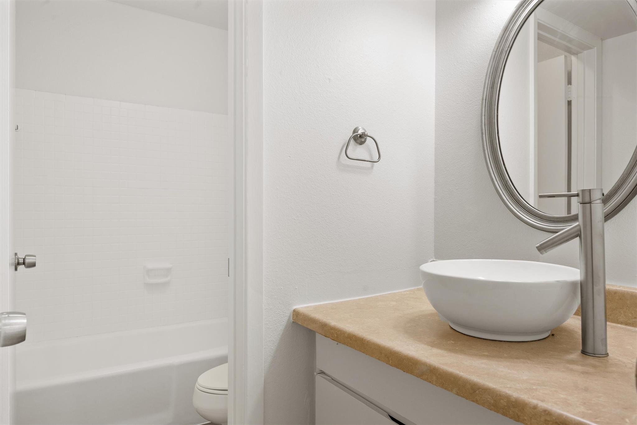 620 South 1st Street, Unit 116 Austin, TX 78704 - Photo 12 of 19 a bathroom with a granite countertop sink toilet and shower
