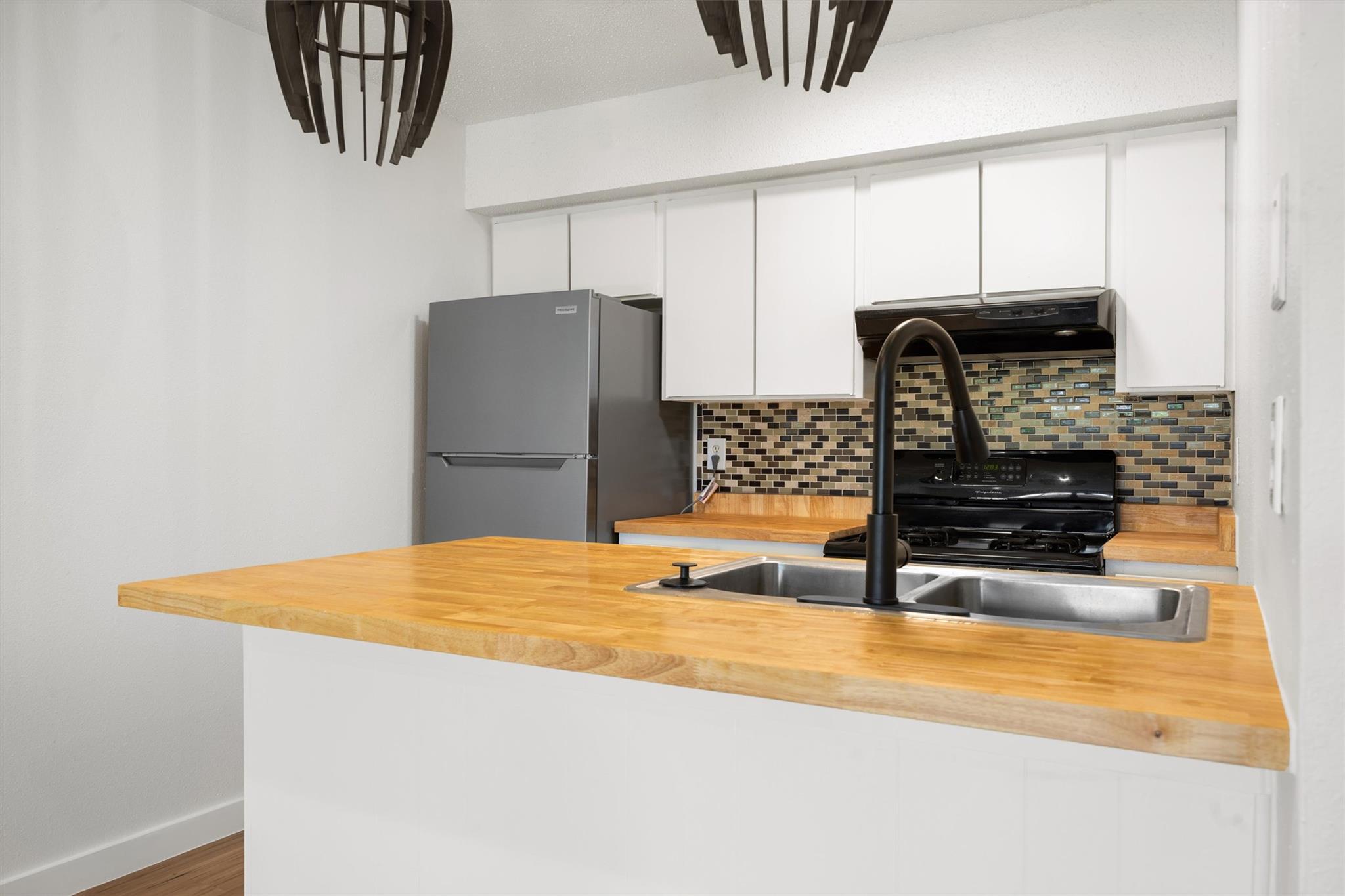 620 South 1st Street, Unit 116 Austin, TX 78704 - Photo 4 of 19 a kitchen with stainless steel appliances granite countertop a refrigerator and a stove top oven