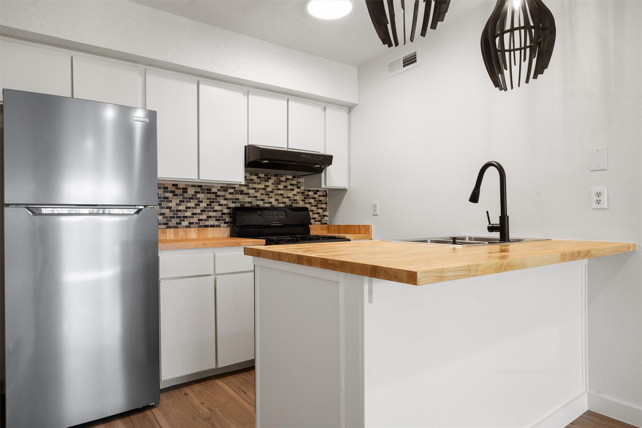 620 South 1st Street, Unit 116 Austin, TX 78704 - Photo 5 of 19 a kitchen with stainless steel appliances a refrigerator a sink a stove and cabinets