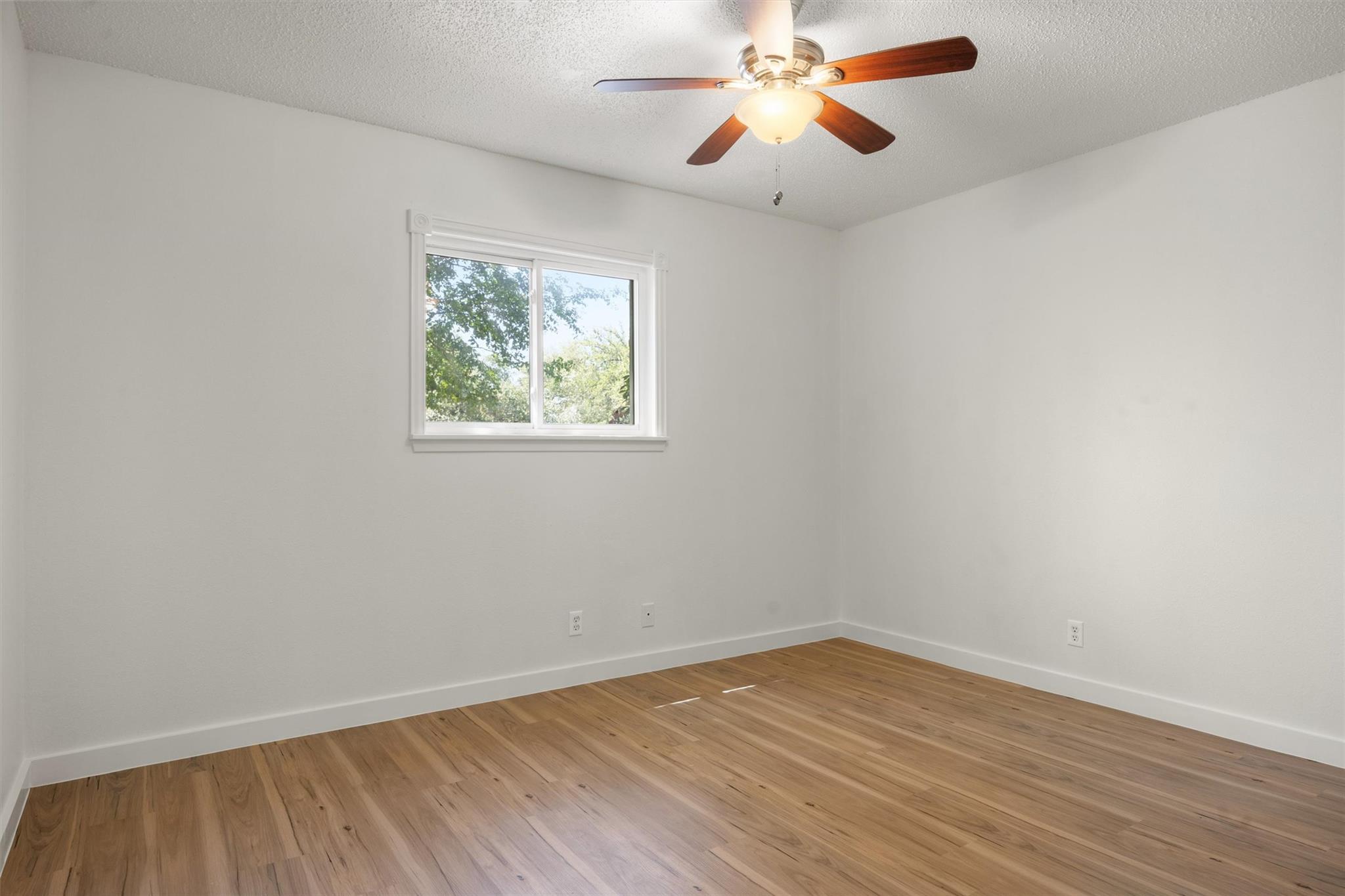 620 South 1st Street, Unit 116 Austin, TX 78704 - Photo 10 of 19 wooden floor in an empty room with a window