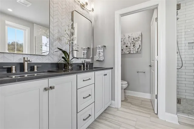 a spacious bathroom with a double vanity sink toilet and shower