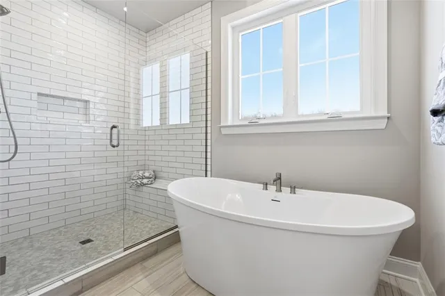 a white bath tub sitting next to a shower