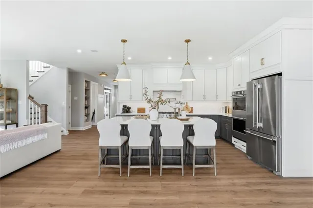 a kitchen with stainless steel appliances kitchen island granite countertop a dining table chairs and granite counter tops