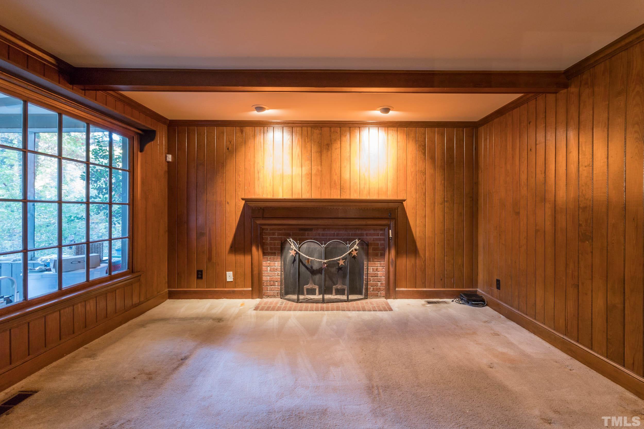 704 Blenheim Drive Raleigh, NC 27612 - Photo 12 of 23 an empty room with a fireplace and window