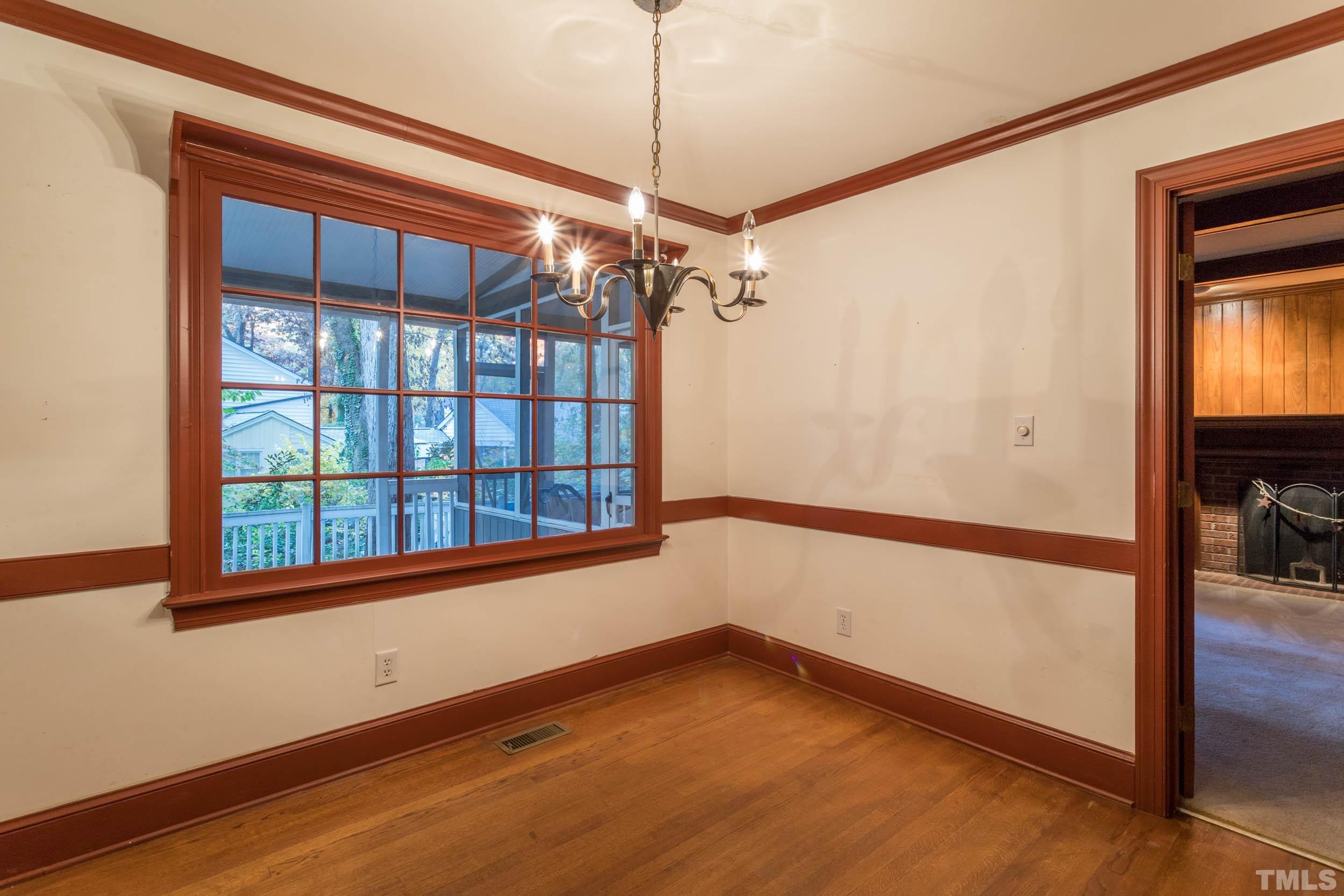 704 Blenheim Drive Raleigh, NC 27612 - Photo 5 of 23 a view of empty room with a window and wooden floor