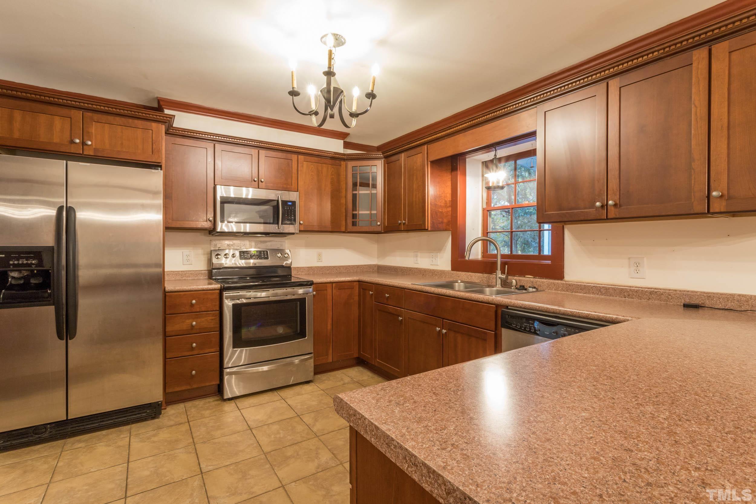 704 Blenheim Drive Raleigh, NC 27612 - Photo 8 of 23 a kitchen with stainless steel appliances granite countertop a sink stove and refrigerator