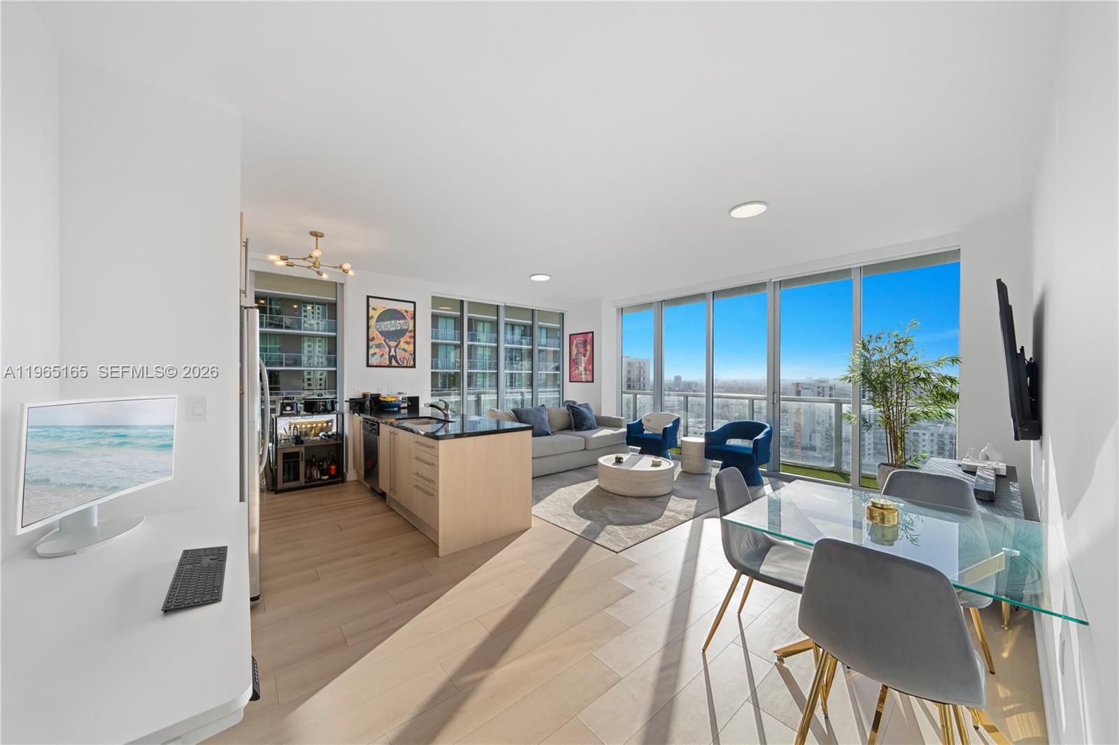 a living room with furniture kitchen view and a large window