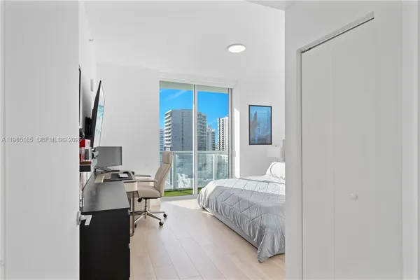 a bedroom with a bed couch and a window