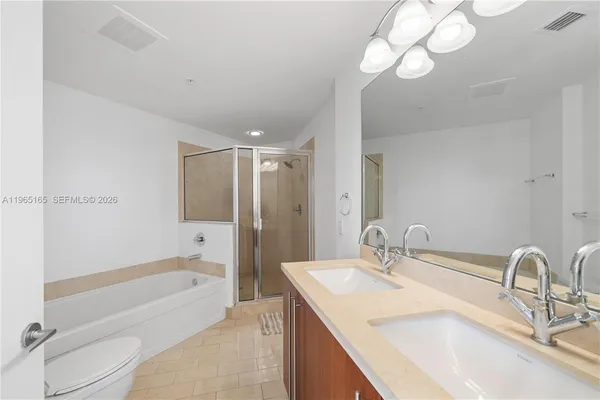 a bathroom with a granite countertop sink a toilet and bathtub