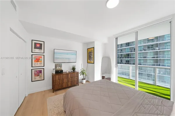 a bedroom with a bed and a large window