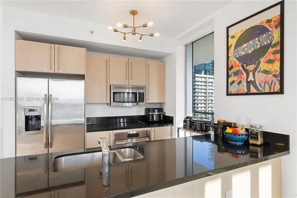 a kitchen with stainless steel appliances granite countertop a refrigerator a stove and white cabinets