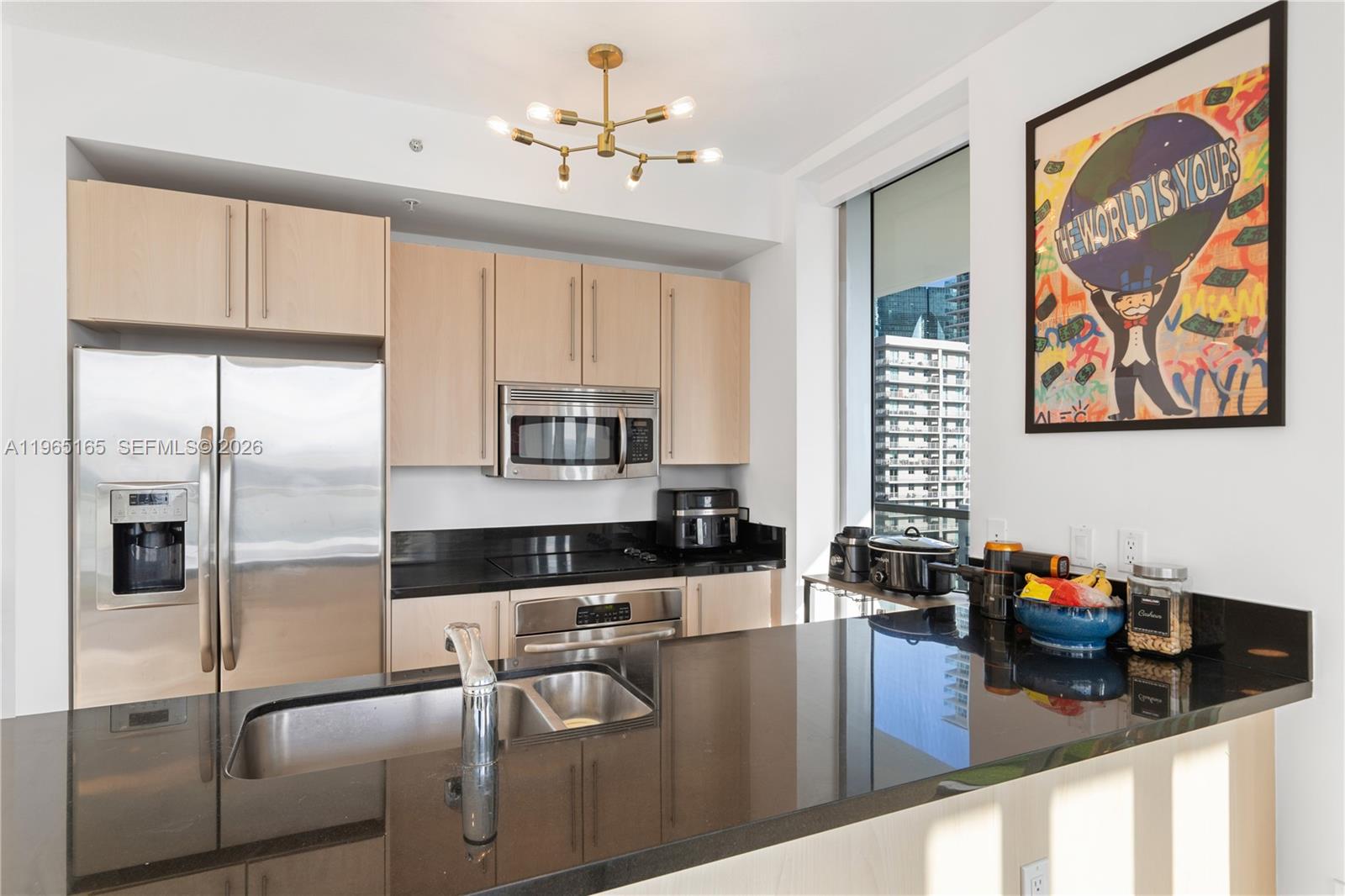 1111 Southwest 1st Avenue, Unit 2114N Miami, FL 33130 - Photo 6 of 23 a kitchen with stainless steel appliances granite countertop a refrigerator a stove and white cabinets