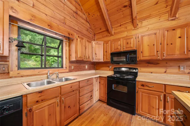 a kitchen with stainless steel appliances granite countertop a sink a stove and microwave