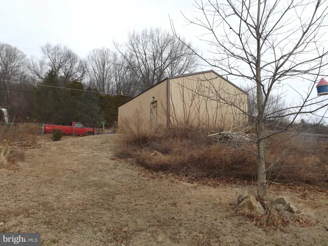 a view of a house with backyard and wooden fence