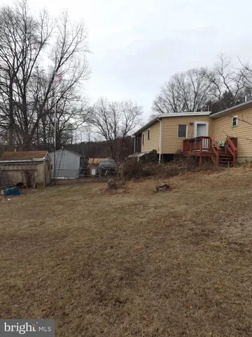 a view of a yard in front of a house with large trees
