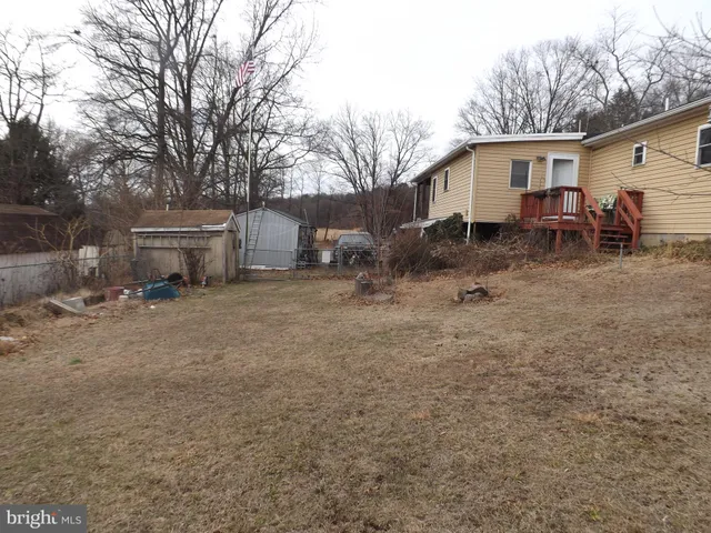 a view of a house with a yard and a tree