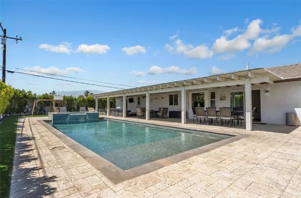 a view of a house with swimming pool and sitting area