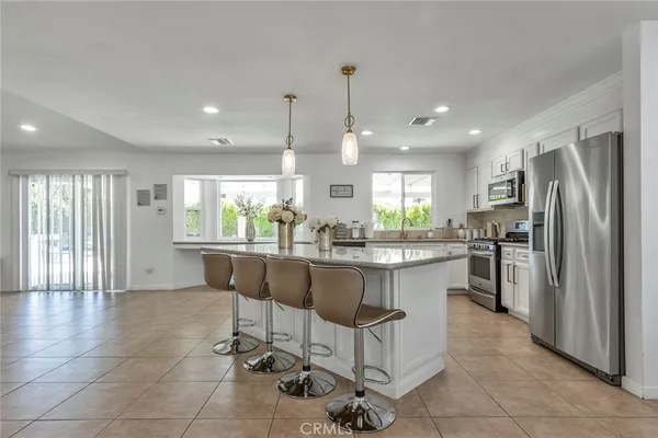 a kitchen with stainless steel appliances granite countertop a refrigerator a sink and a stove