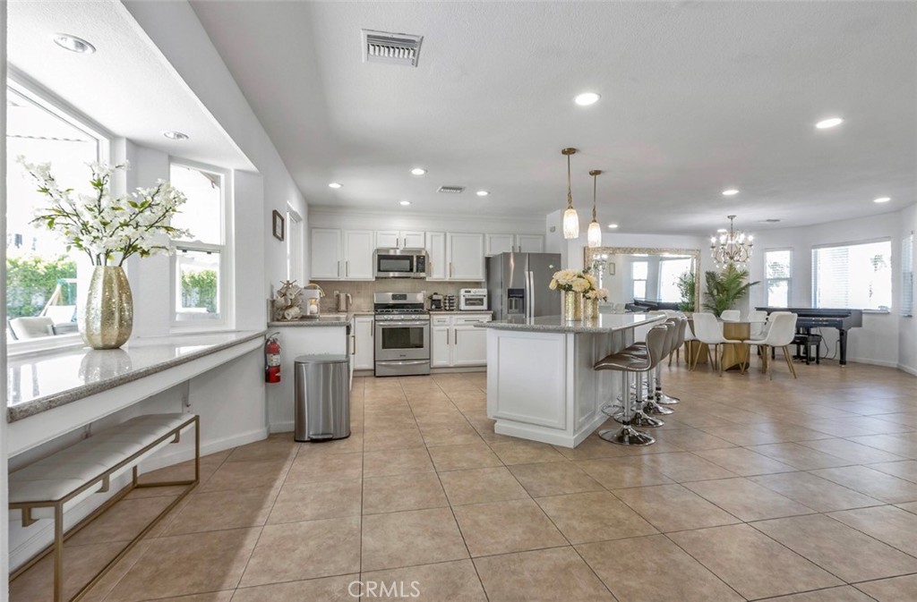 2230 North Volturno Road Palm Springs, CA 92262 - Photo 9 of 34 a kitchen with stainless steel appliances kitchen island granite countertop a sink cabinets and wooden floor