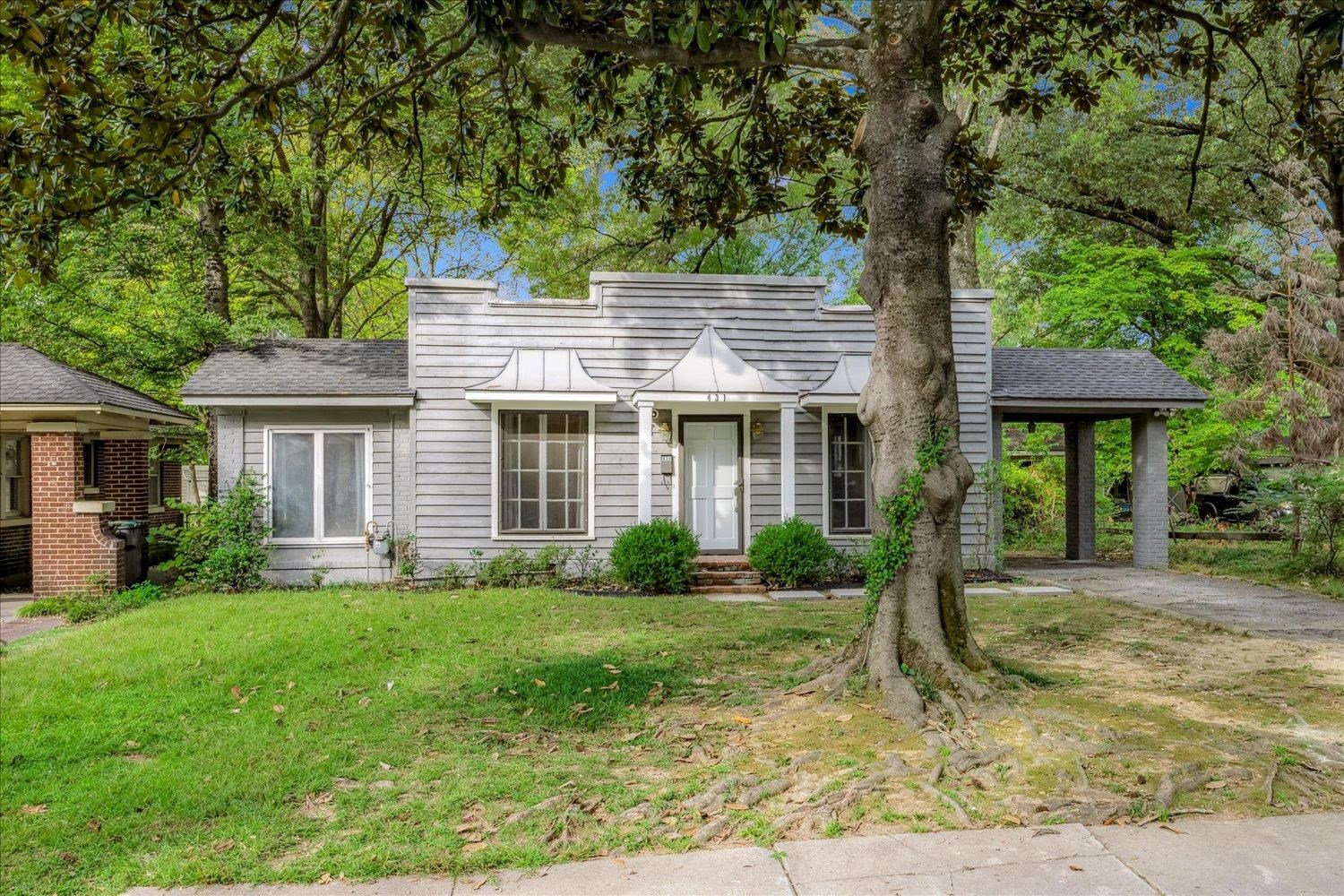 View of front of property featuring a front yard, a chimney, and roof with shingles
