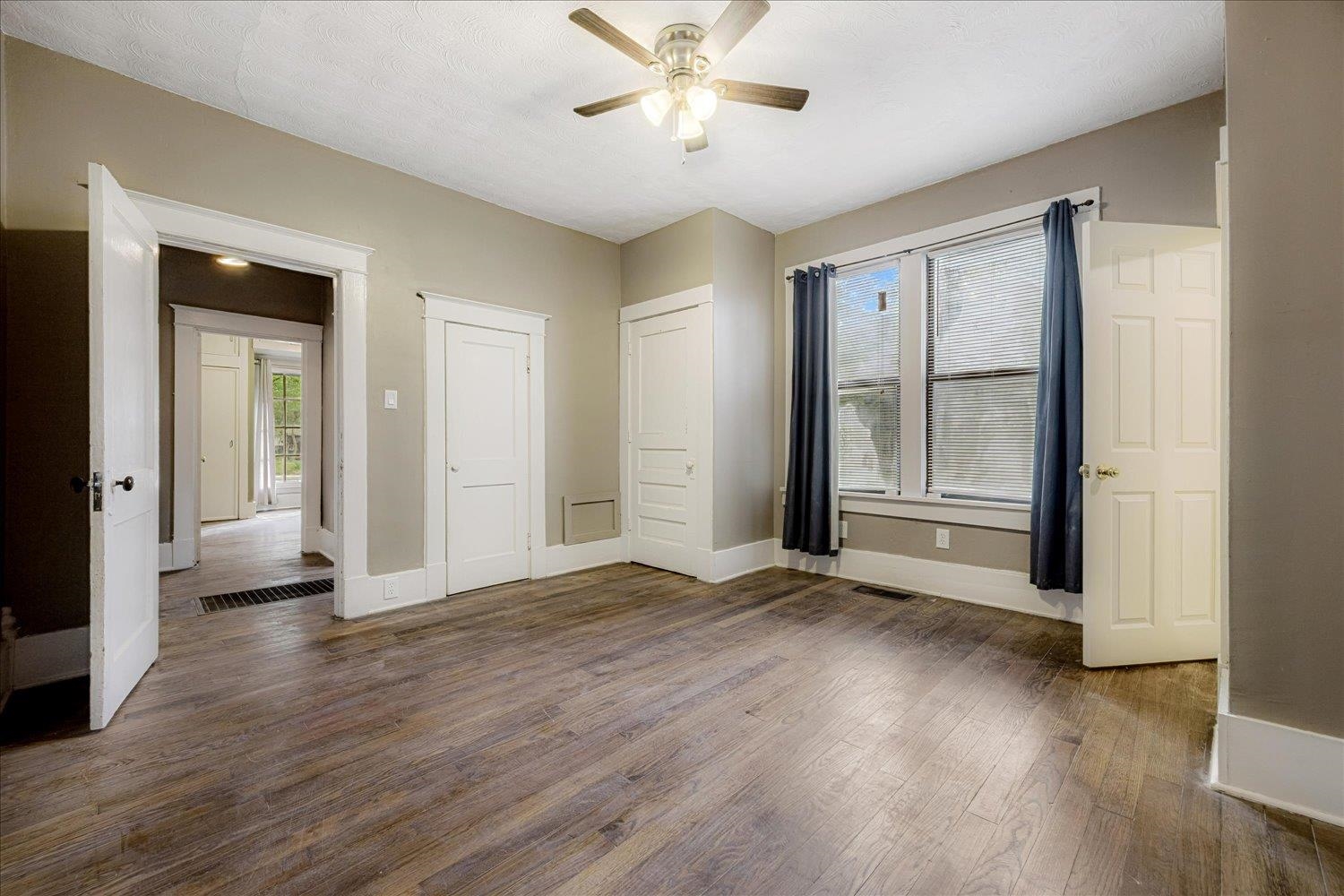 431 Alexander Street Memphis, TN 38111 - Photo 9 of 13 Unfurnished bedroom featuring dark wood-style flooring, multiple windows, ceiling fan, and a closet