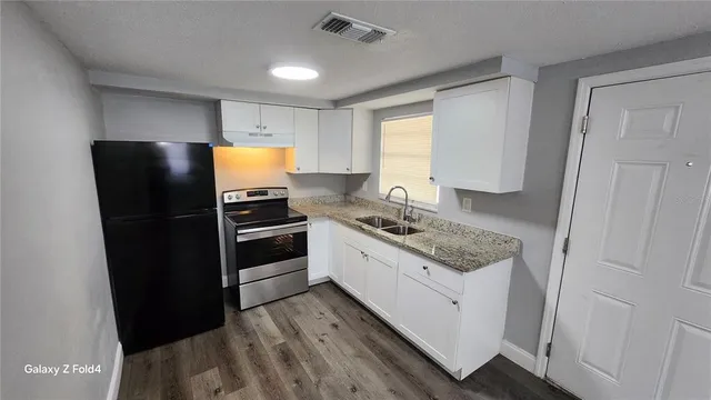 a kitchen with stainless steel appliances granite countertop a refrigerator and a stove