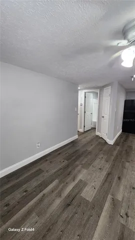 a view of empty room with wooden floor