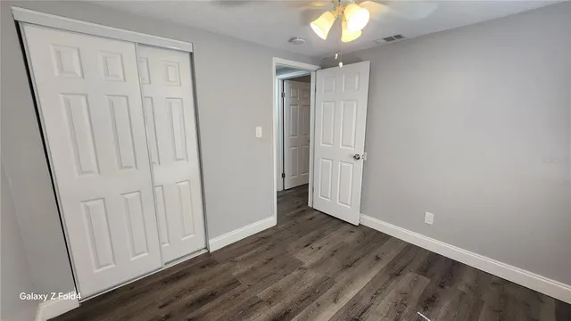 a view of empty room with wooden floor