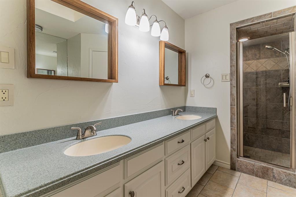 127 Nicklaus Nook Lancaster, TX 75146 - Photo 16 of 37 Full bathroom featuring double vanity, a stall shower, and light tile patterned flooring
