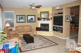 4912 Borders Street Simi Valley, CA 93063 - Photo 3 of 10 a living room with furniture a flat screen tv and a fireplace