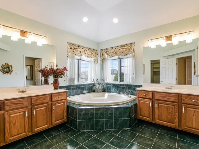 a room with kitchen island granite countertop lots of white stainless steel appliances a sink and cabinets