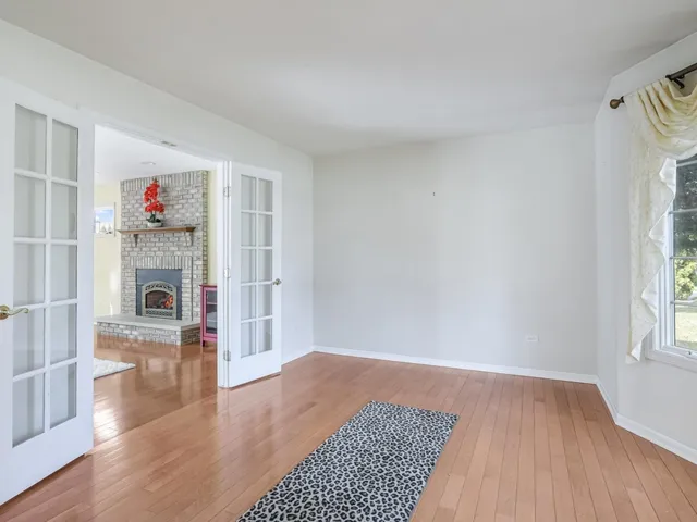 a view of a livingroom with wooden floor and a fireplace